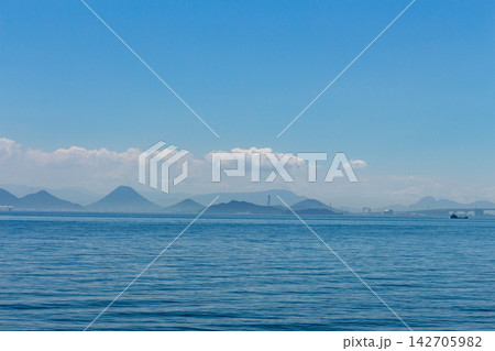 島々と遠くの橋を望む青空と穏やかな海上、遠くの山並みが広がる瀬戸内海の遠景 142705982