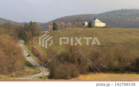 The church stands on a hill with a colorful forest in the background The church stands on a hill with a colorful forest in the background 142706536