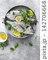 Fish raw dorado sea bream with lemon slices and herbs 142706668