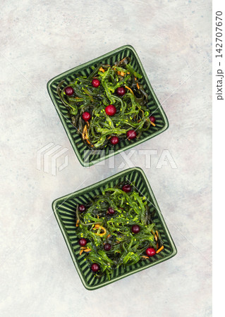 Vegan seaweed salad with cranberries in bowl. 142707670