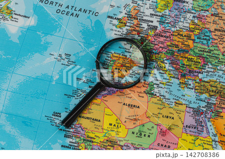 Exploring a map with a magnifying glass over Spain and its surroundings 142708386