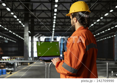 Isolated mockup on laptop with professional engineer in heavy industry warehouse facility, manufacturing process for production line. Industry hall operations with worksite worker. Isolated mockup on laptop with professional engineer in heavy industry warehouse facility, manufacturing process for production line. Industry hall operations with worksite worker. 142709990