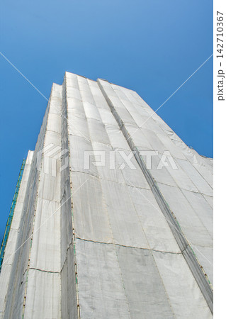 養生メッシュシートで囲われた建設中のマンション 142710367