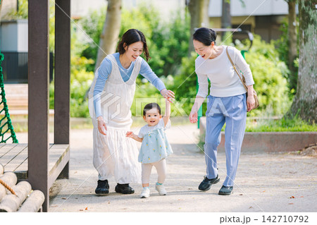 公園を散歩する親子三世代ファミリー 公園を散歩する親子三世代ファミリー 142710792