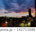 雨上がりの駅前と夕焼けに染まる都市の風景 142711086