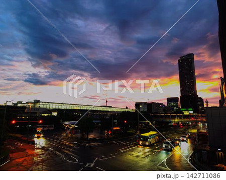 雨上がりの駅前と夕焼けに染まる都市の風景 雨上がりの駅前と夕焼けに染まる都市の風景 142711086