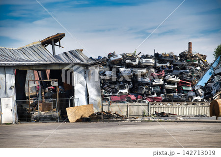 Massive Scrap Metal Pile In Industrial Junkyard With Crushed Cars And Rusted Debris Under Cloudy Sky 142713019