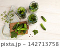 Cucumbers are being prepared for pickling with dill and spices on a kitchen table 142713758