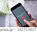 スマートフォンでサブスクリプションサービスに登録する手元写真(スマホ画面はオリジナル制作のイメージ) 142713827