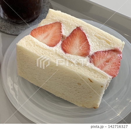 Soft strawberry sando filled with fluffy whipped cream and juicy strawberries. Light, sweet, and refreshing, offering a clean and charming dessert perfect for modern cafe visuals. Soft strawberry sando filled with fluffy whipped cream and juicy strawberries. Light, sweet, and refreshing, offering a clean and charming dessert perfect for modern cafe visuals. 142716327