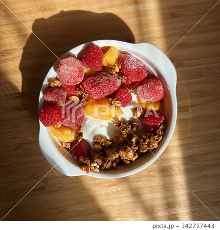 Creamy yogurt bowl topped with fresh fruits and crunchy toppings, offering a smooth texture and refreshing taste. Light, wholesome, and visually appealing, perfect for breakfast or healthy snack. Creamy yogurt bowl topped with fresh fruits and crunchy toppings, offering a smooth texture and refreshing taste. Light, wholesome, and visually appealing, perfect for breakfast or healthy snack. 142717443