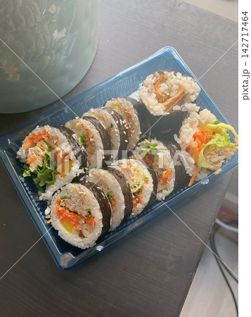 Fresh kimbap rolls filled with rice, vegetables, and savory ingredients, neatly wrapped in seaweed. Colorful, balanced, and satisfying, offering a classic Korean flavor with a clean, appetizing look. 142717464