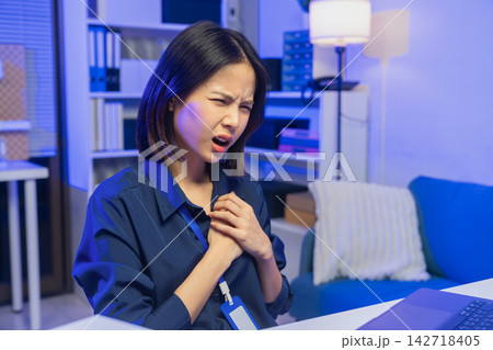 Young Asian businesswoman experiencing chest pain while working in an office. Young Asian businesswoman experiencing chest pain while working in an office. 142718405