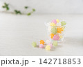 柔らかい自然光がガラス器とこぼれた砂糖菓子を包む、白を基調とした爽やかな和モダン写真 142718853