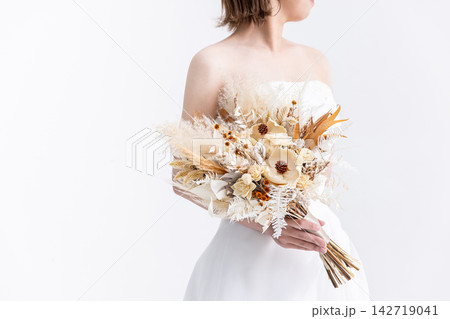 花束を抱えているウエディングドレスの女性 花束を抱えているウエディングドレスの女性 142719041