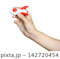 Human hand holding a white and red toy rocket model against. Business startup, innovation, and growth mission concept. Minimalist studio shot for success and ambition. 142720454
