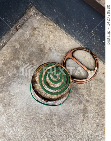 コンクリート床の上に置かれた蚊取り線香と缶の器 コンクリート床の上に置かれた蚊取り線香と缶の器 142720880