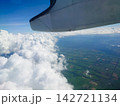 飛行機の窓から見る雲海と大地-A sea of clouds and the land seen- 142721134