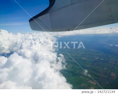 飛行機の窓から見る雲海と大地-A sea of clouds and the land seen- 142721134