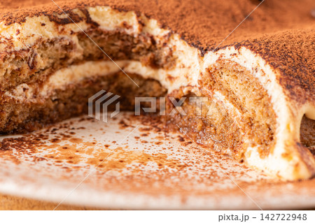 Delicious homemade tiramisu cake topped with cocoa Delicious homemade tiramisu cake topped with cocoa 142722948