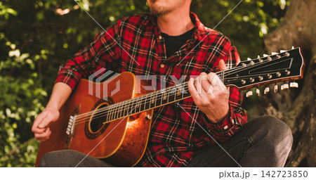 Closeup of Musician Hands Playing Acoustic Guitar 142723850