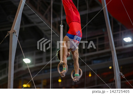 Gymnast performing handstand on rings Gymnast performing handstand on rings 142725405
