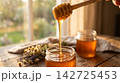 Pure organic liquid honey dripping smoothly and glowing under warm natural lighting. 142725453