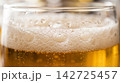 Extreme close up texture of a refreshing cold pint glass highlighting rising carbonation and amber liquid glow. 142725457