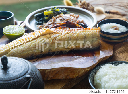 Charcoal-grilled Shima Hokke served with lime, refreshing grated daikon, and traditional sides. Golden, crispy skin gives way to tender ivory flesh, perfectly complemented by a bowl of steamed white 142725461