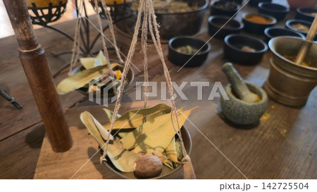Traditional apothecary shelves display medicinal herbs, tinctures and botanical ingredients in glass jars. Concepts: herbal medicine history, natural remedies, pharmaceutical heritage, 142725504