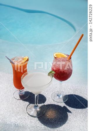 Colorful cocktails served in elegant glasses beside a refreshing swimming pool, showcasing vibrant drinks with garnishes, perfect for summer relaxation and enjoyment Colorful cocktails served in elegant glasses beside a refreshing swimming pool, showcasing vibrant drinks with garnishes, perfect for summer relaxation and enjoyment 142726229