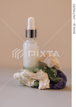 A close-up of a white glass bottle with a dropper with a moisturizing serum with bubbles A close-up of a white glass bottle with a dropper with a moisturizing serum with bubbles 142726265