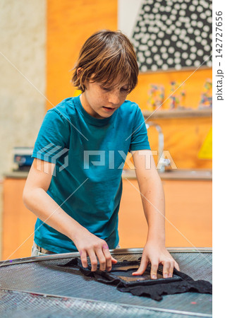 Boy experimenting with hands on science activity in a learning space indoors with interactive equipment STEM education curiosity creative play concentration and walking. 142727656