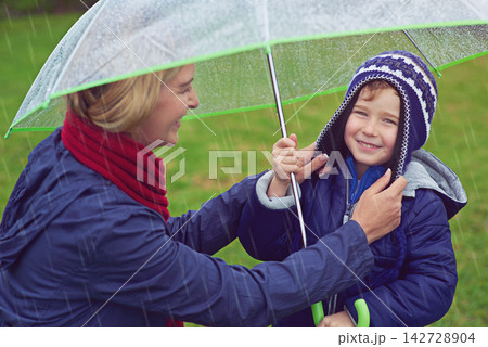 Mother, boy and rain for umbrella, smile and child with portrait for winter and safety of waterproof. Happiness, mom and adorable kid in park, parent and youth in weather of Austin and joy for water Mother, boy and rain for umbrella, smile and child with portrait for winter and safety of waterproof. Happiness, mom and adorable kid in park, parent and youth in weather of Austin and joy for water 142728904