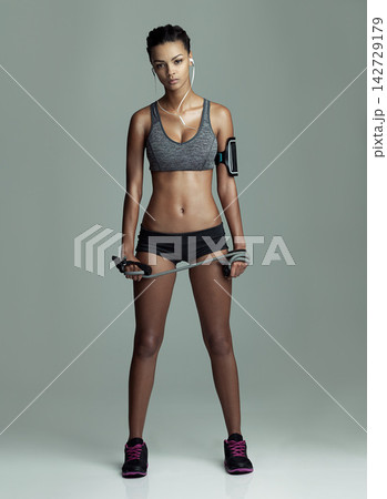 Body, jump rope and music with portrait of woman in studio isolated on gray background. Exercise, skipping and workout with serious athlete training for fitness challenge, health or performance 142729179
