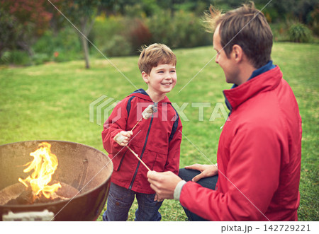 Father, outdoors and son with marshmallow for roasting on flame with bonding for happiness. Child development, smile and camping with scenic campsite in winter morning on weekend away to Germany. Father, outdoors and son with marshmallow for roasting on flame with bonding for happiness. Child development, smile and camping with scenic campsite in winter morning on weekend away to Germany. 142729221