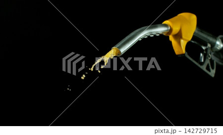Close-up of Gasoline Spurting from the Gas Pump Nozzle , Dark Grey Background 142729715