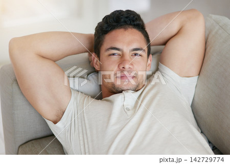 Happy, relax and portrait of man on sofa in living room with positive, good and confident attitude at home. Smile, rest and handsome male person from Spain laying on couch in lounge at apartment. 142729774