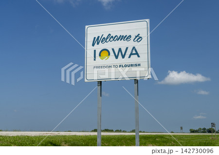 Welcome to Iowa - roadside sign against blue sky at state border with Missouri, travel concept Welcome to Iowa - roadside sign against blue sky at state border with Missouri, travel concept 142730096