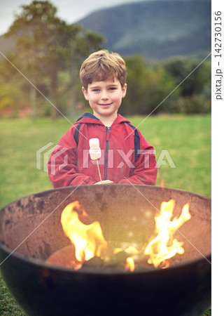 Boy, fire and portrait in outdoors with marshmallow for roasting on flames for happiness. Camping, bonding and child development with scenic mountain in winter morning with learning in Sweden. Boy, fire and portrait in outdoors with marshmallow for roasting on flames for happiness. Camping, bonding and child development with scenic mountain in winter morning with learning in Sweden. 142730156