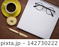 blank spiral notebook with grid paper, flat lay with coffee and reading glasses on textured art paper 142730222