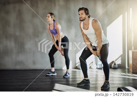 Training, man and woman in gym with kettlebell, fitness and power at workout challenge together. Couple, sports club and personal trainer with weights, muscle development and healthy body exercise Training, man and woman in gym with kettlebell, fitness and power at workout challenge together. Couple, sports club and personal trainer with weights, muscle development and healthy body exercise 142730819