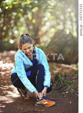Woman, runner and ankle injury in nature, forest and stop training to massage joint pain on path. Girl, person and accident in workout for fitness, health and thinking in woods for hiking in morning 142731332