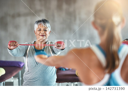 Personal trainer, fitness and mature woman with band for training, exercise and cardio workout. Sports coach, retirement and women for wellness, health and wellbeing with stretching equipment in gym 142731390