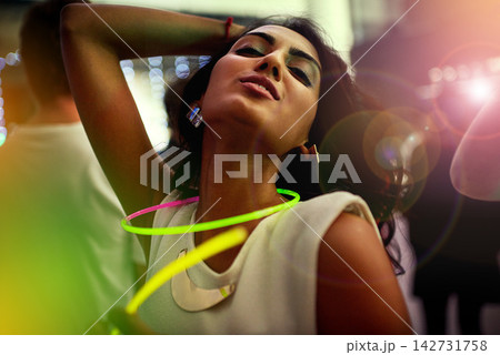 Dancing, lights and woman in nightclub for fun, music or happy weekend at social event. Nightlife, energy and girl at neon rave club with lens flare, smile and celebration at party with youth culture 142731758