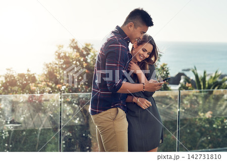 Happy couple, hug and balcony with phone for social media, online browsing or funny post in nature. Young man and woman with smile or embrace on mobile smartphone for outdoor chatting, texting or app Happy couple, hug and balcony with phone for social media, online browsing or funny post in nature. Young man and woman with smile or embrace on mobile smartphone for outdoor chatting, texting or app 142731810