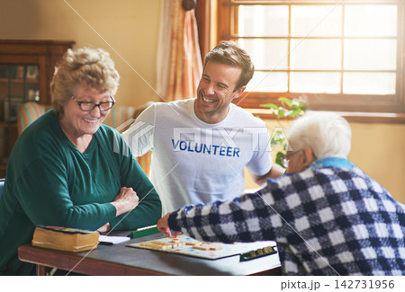 Volunteer, man and happy with senior people in retirement home, board game and social interaction for advocacy. Male assistant, elderly women and scrabble for volunteering and community service. Volunteer, man and happy with senior people in retirement home, board game and social interaction for advocacy. Male assistant, elderly women and scrabble for volunteering and community service. 142731956