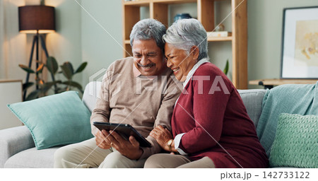 Senior couple, happy and laughing with tablet, streaming and communication in living room. People, mature man and woman on funny meme, couch and house together in retirement with digital technology 142733122