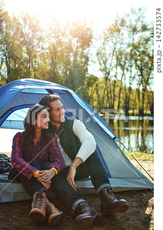 Camping, tent and couple relax in woods with love and happiness together on adventure. People, smile and thinking of journey in nature with chat on holiday, vacation or travel in forest at river Camping, tent and couple relax in woods with love and happiness together on adventure. People, smile and thinking of journey in nature with chat on holiday, vacation or travel in forest at river 142733574