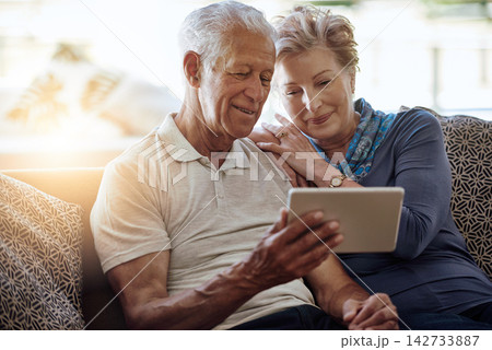 Mature couple, lounge and tablet for watch, digital and online for search, information and show on app in house. Conversation, man and woman with news to relax in home, smile and download of movie Mature couple, lounge and tablet for watch, digital and online for search, information and show on app in house. Conversation, man and woman with news to relax in home, smile and download of movie 142733887